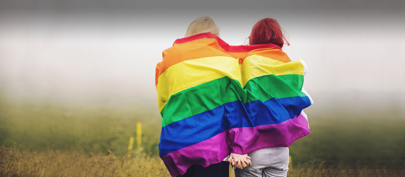 Two same sex couple with rainbow flag 