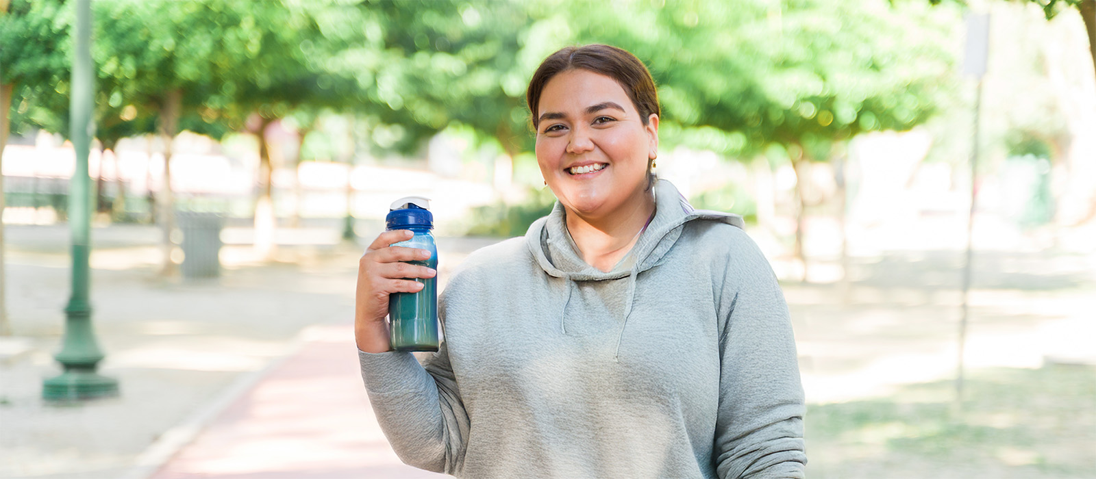 young woman outdoors fitness holding water bottle