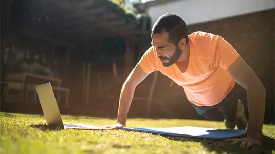 fit man doing push ups along with virtual class