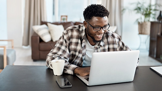 diverse man using laptop at home