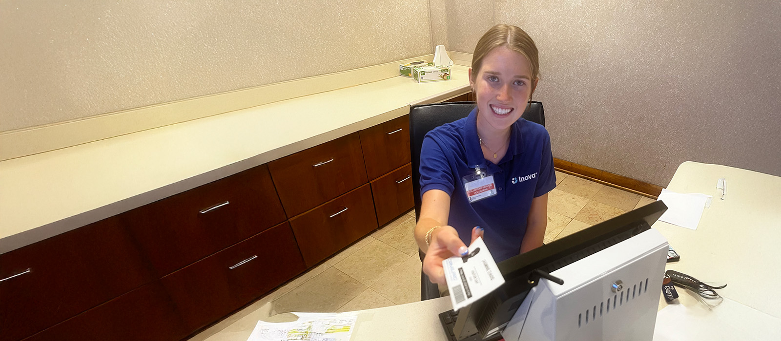 Female volunteer student smiling at reception desk